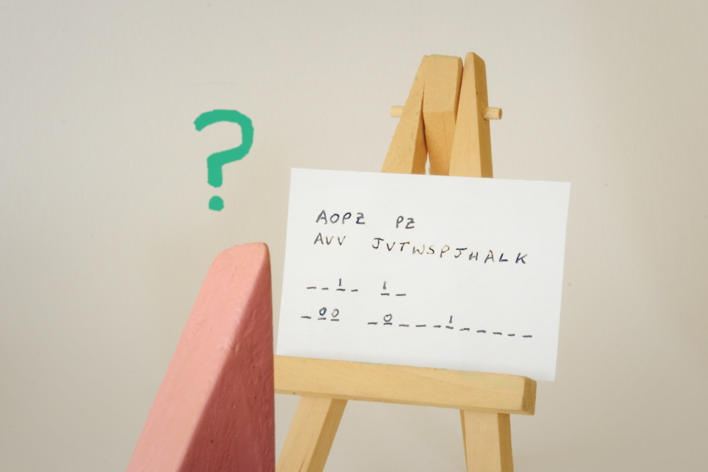 Block Woman gazes at white horizontal sheet of paper propped up on a light-colored wood easel. A green question mark symbol hangs above her pointed head.
