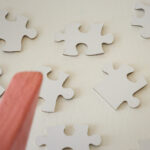 Block Woman surveys white puzzle pieces