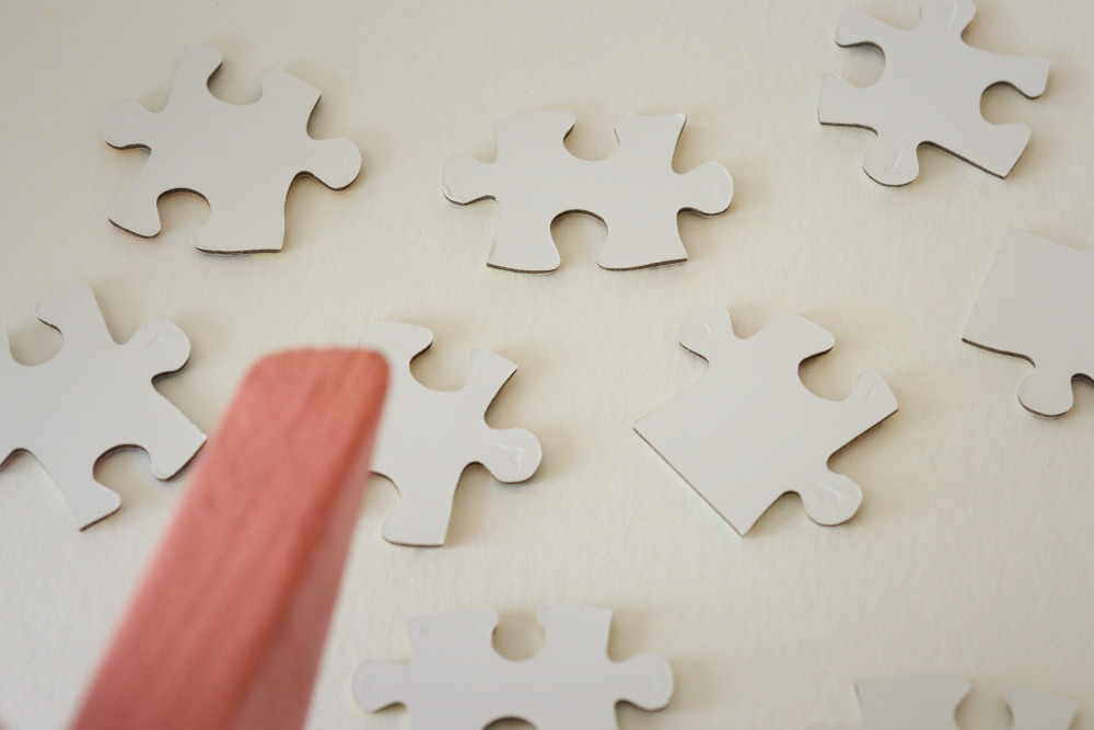 Block Woman surveys white puzzle pieces